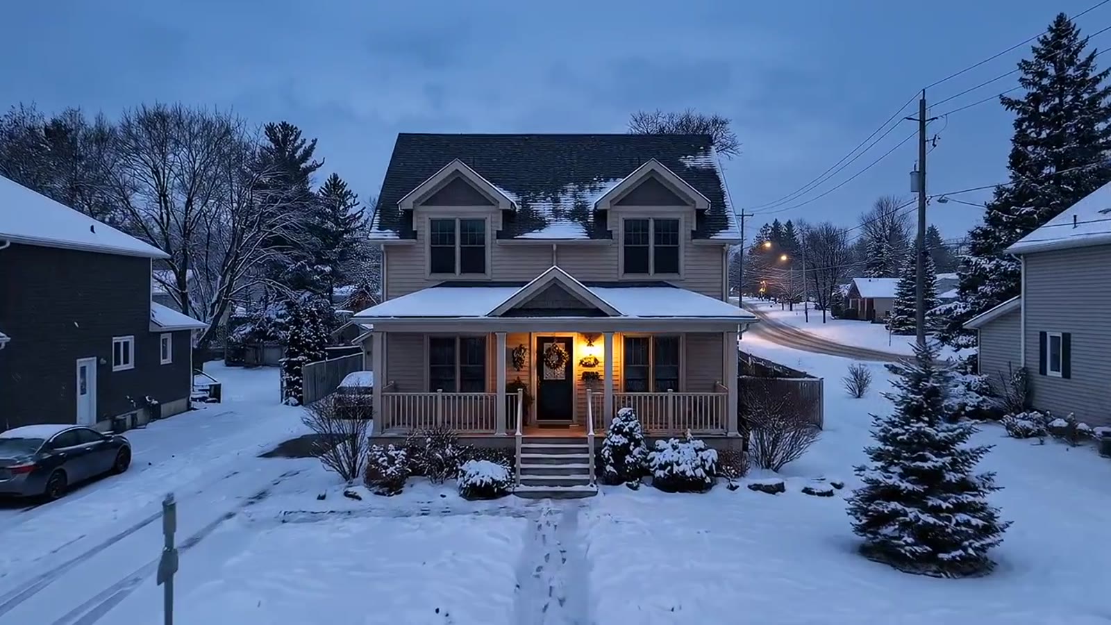 Snow-covered house with porch light on